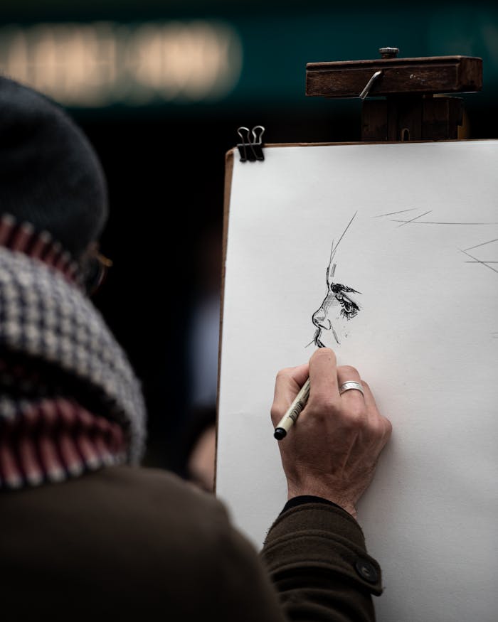 services-01 Close-up of an artist sketching a portrait on the street in Paris, capturing creative expression.